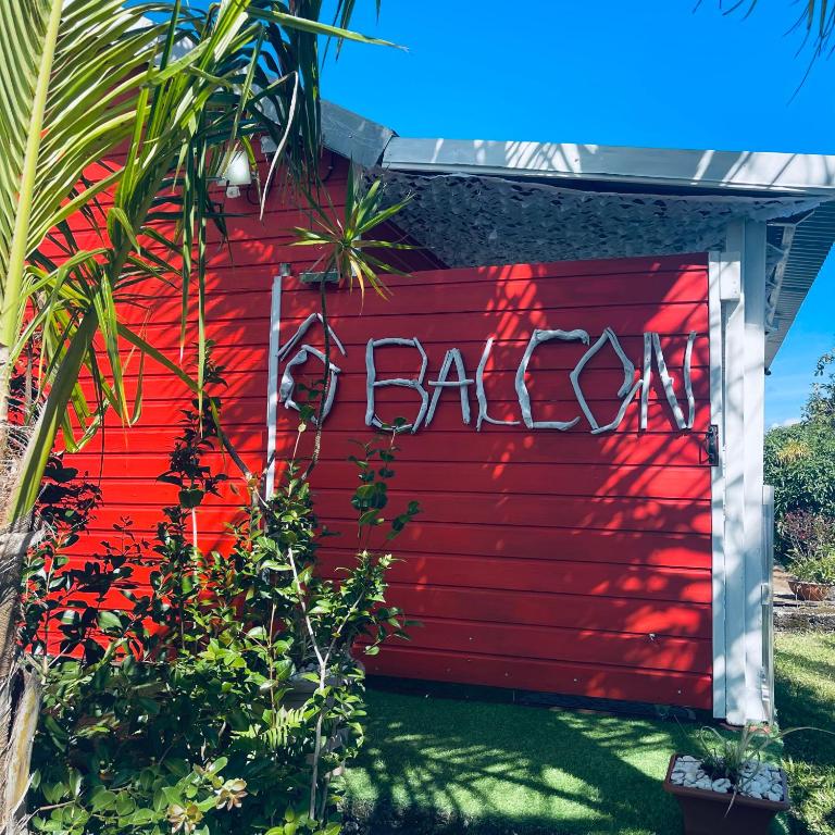 a red wall with the word backyard written on it at Ô Balcon in Sainte-Rose