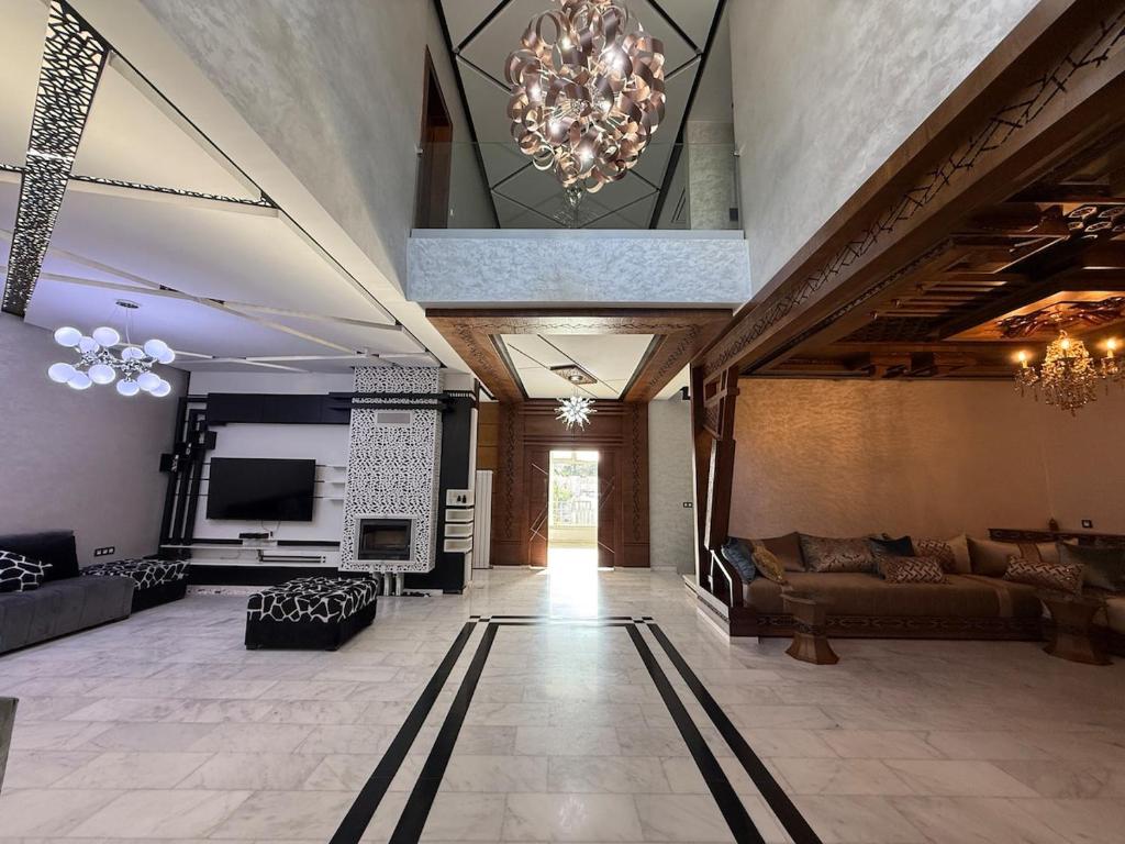 a large living room with couches and a chandelier at Exceptional Villa Pool in Oujda