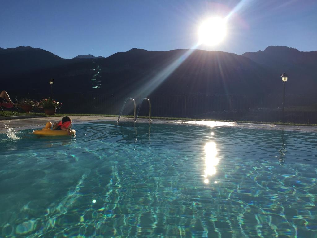 ein Kind in einem Pool mit einem Floß im Wasser in der Unterkunft Agritur La Pieve in Thayl