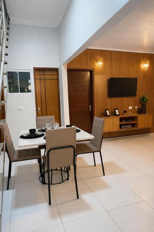 a dining room with a table and chairs and a television at CS2 - Ampla - Suítes e Ar-Cond em Todos os Quartos in Juazeiro do Norte