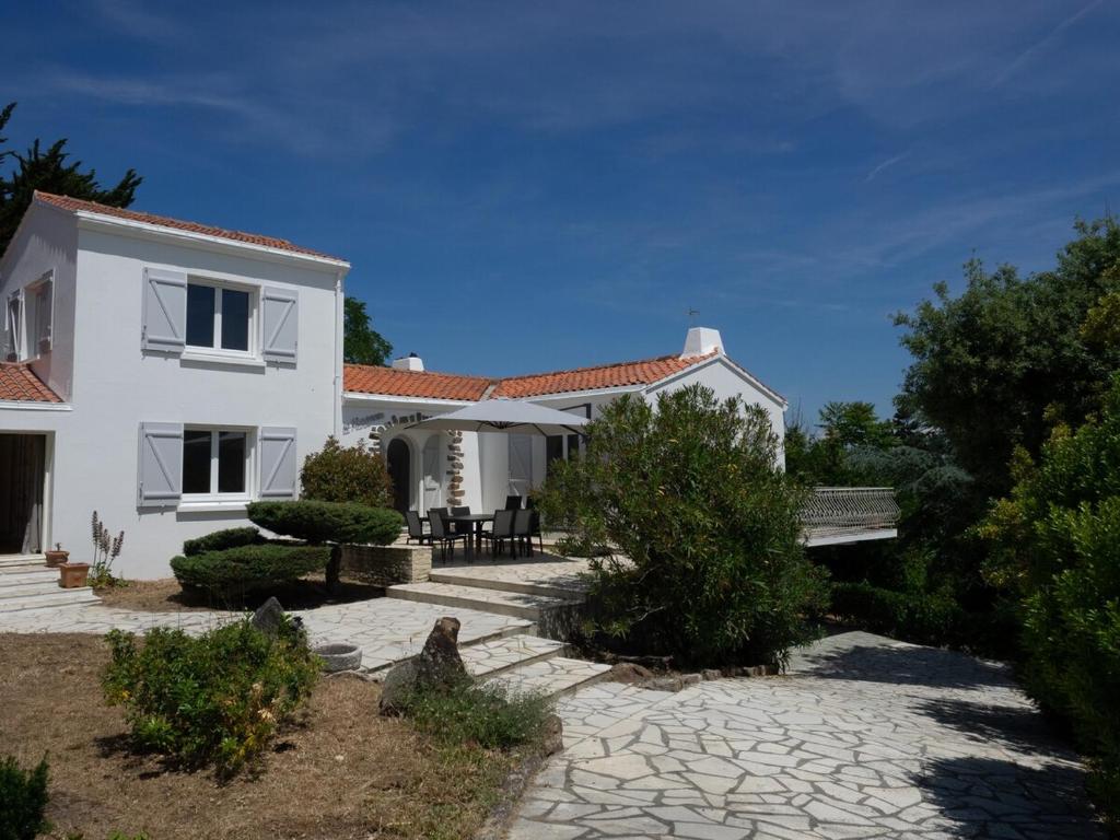 a white house with a patio and a yard at Renovated villa by the ocean in Barbâtre