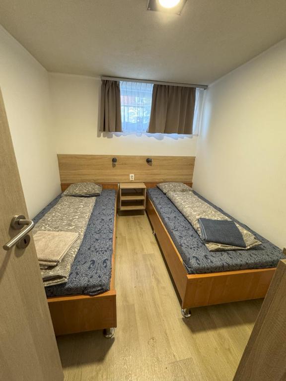 two beds are in a room with a door at Beregi Apartman in Tiszaújváros