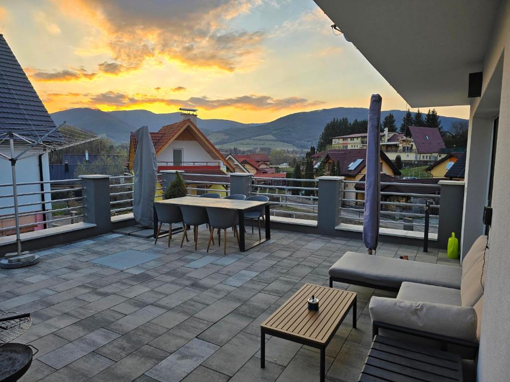 a patio with a table and chairs on a balcony at Dom pri jazere Nitrianske Rudno in Kostolná Ves
