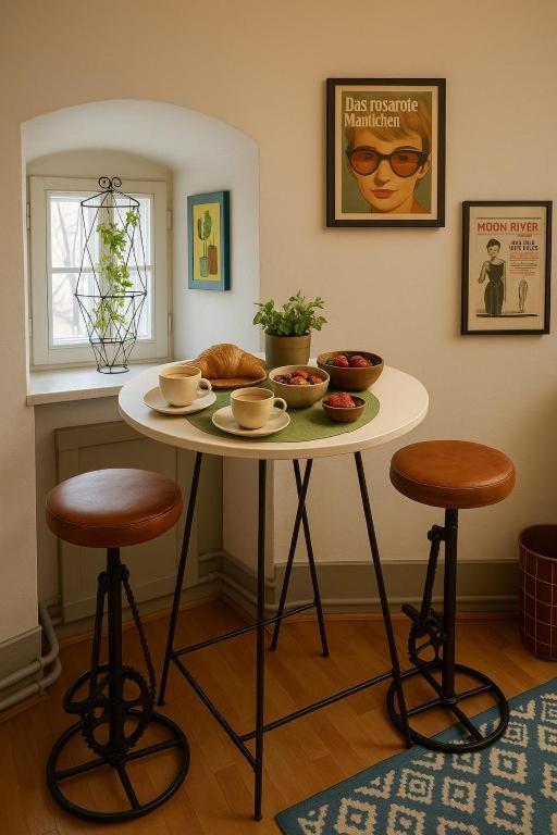 a table with two stools and a table with food on it at 18 Steps to a Secret Tower in Porrentruy