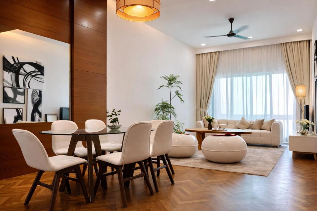 a living room with a table and chairs and a couch at Straits Quay Seafront Suite l Panoramic Seaview in Tanjong Tokong