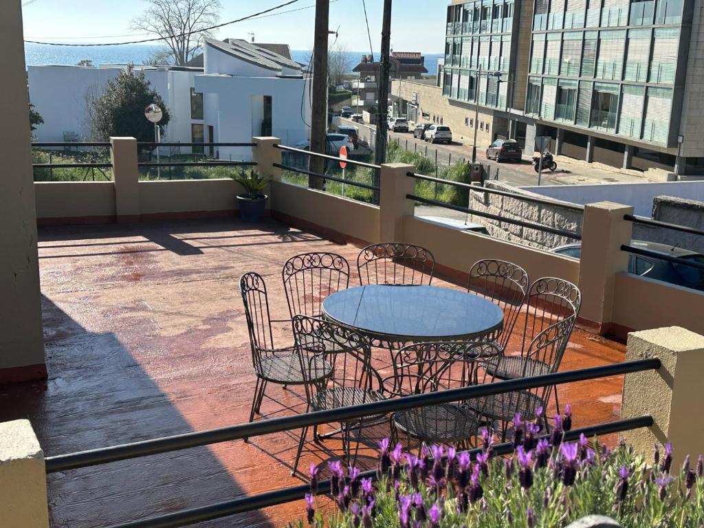 a patio with a table and chairs on a balcony at Casa As Estelas Camino de santiago por la costa Playa America in Nigrán