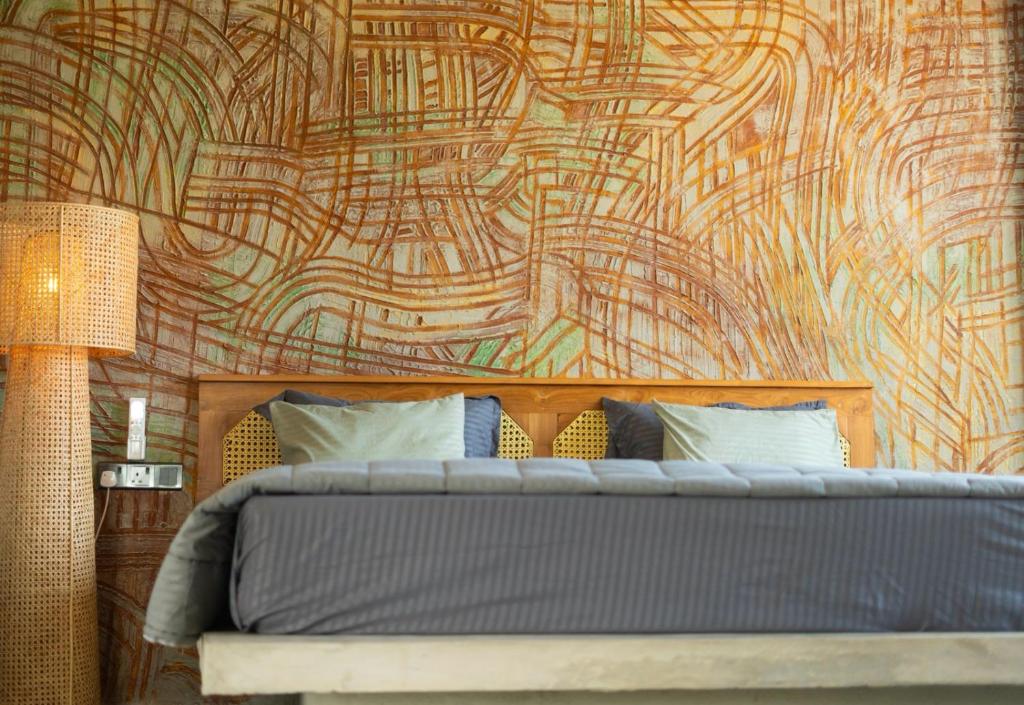 a bedroom with a bed and a wall with a mural at BUKU BUKU by Bara Beach in Galle