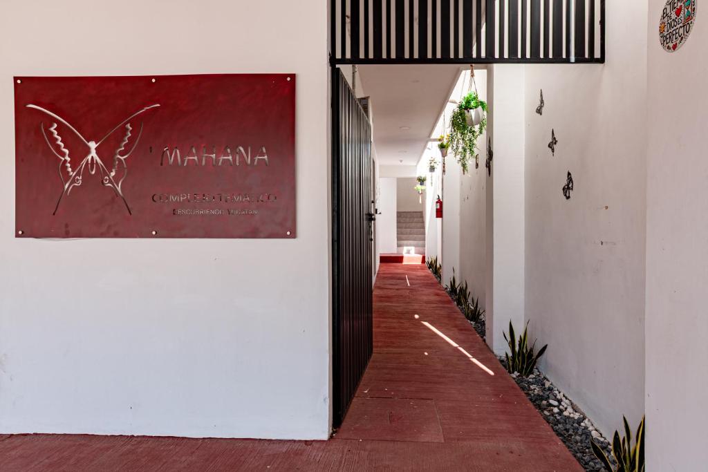 a corridor of a building with a sign on the wall at X Mahaná Apartamentos Temáticos in Mérida