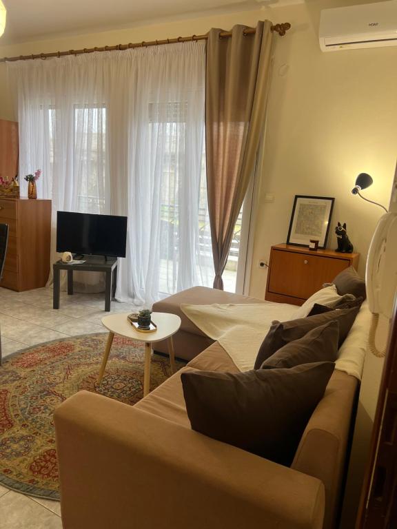 a living room with a couch and a tv in a room at Castle Town Apartment in Dhidhimótikhon