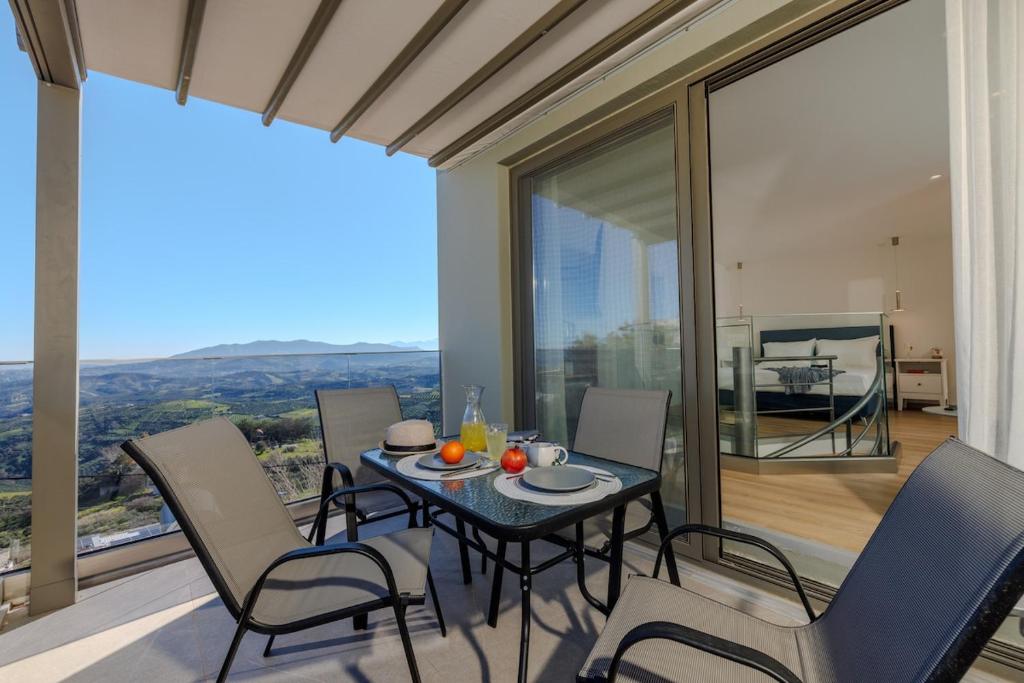 a dining room with a table and chairs on a balcony at Evmaria Luxury Cottage in Agios Myronas
