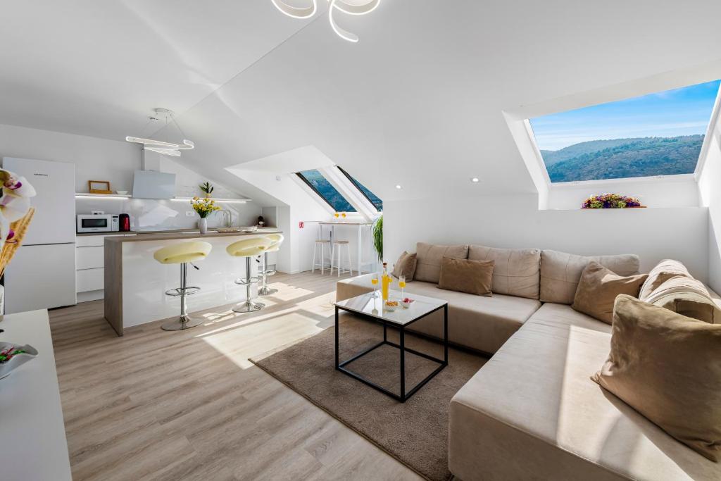 a white living room with a couch and a table at Mirante in Mokošica