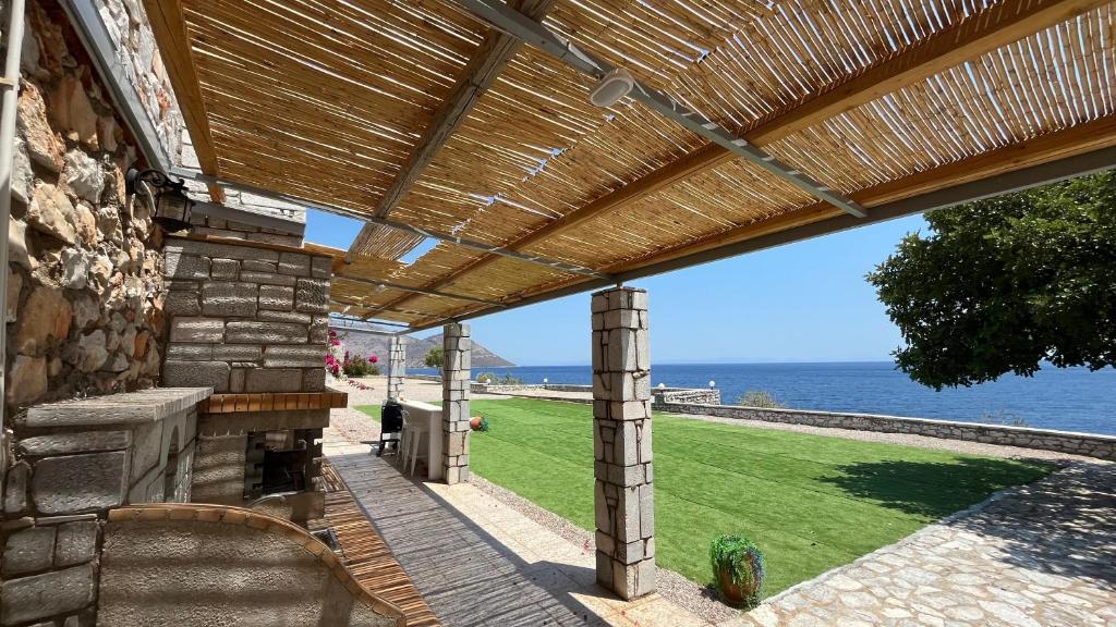 a wooden pergola on the side of a building at Magic estate on the wave 2 by Villa Lagkadaki in Kotronas