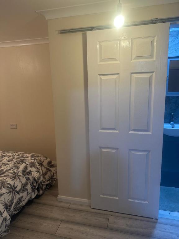 a white door in a room with a bed at Godwinning lodge in Thamesmead