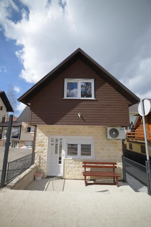 a house with a bench in front of it at Planinski vuk chalet in Žabljak
