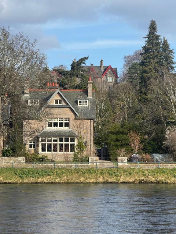 a house on the banks of a river at St Giles Lodge in Inverness