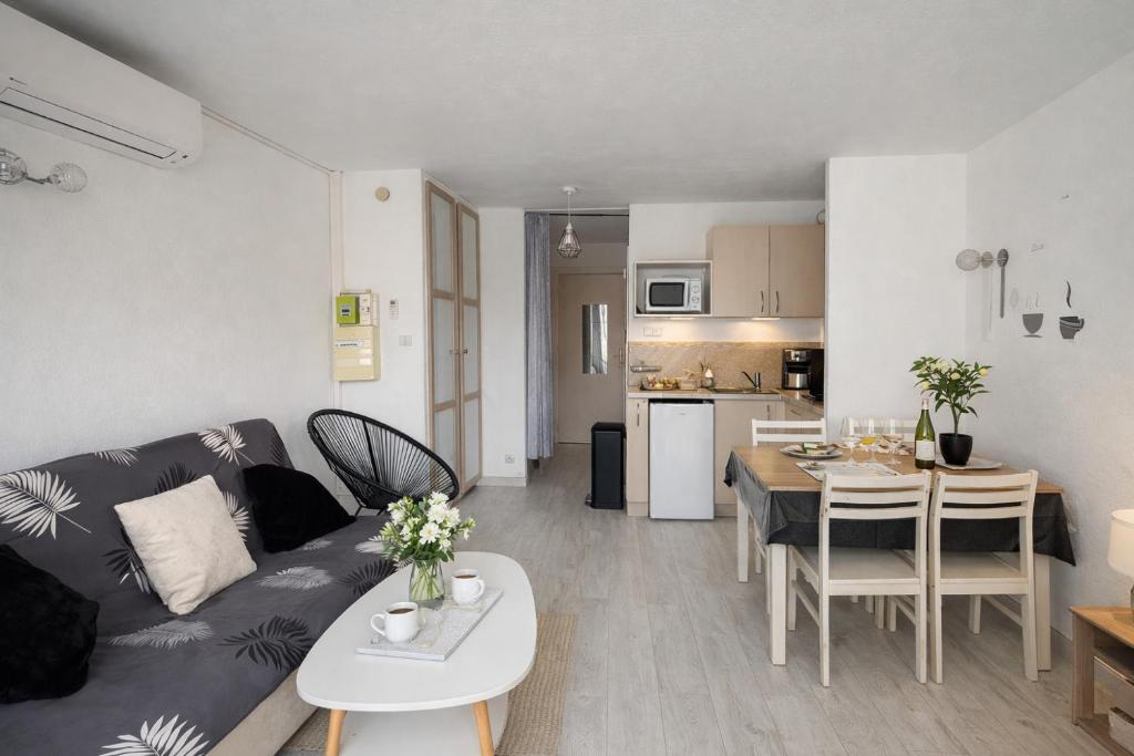 a living room and kitchen with a couch and a table at centre port le cocon 4 couchages in Cap d'Agde