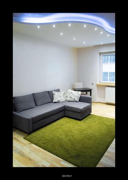 a living room with a couch and a green rug at Casa Porta D'Amalfi vicino Stazione e terminal Sita Salerno in Salerno
