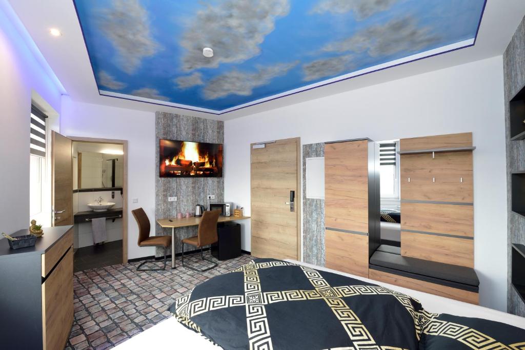 a bedroom with a blue ceiling with a bed and a desk at Sleep Inn Hotel in Paderborn
