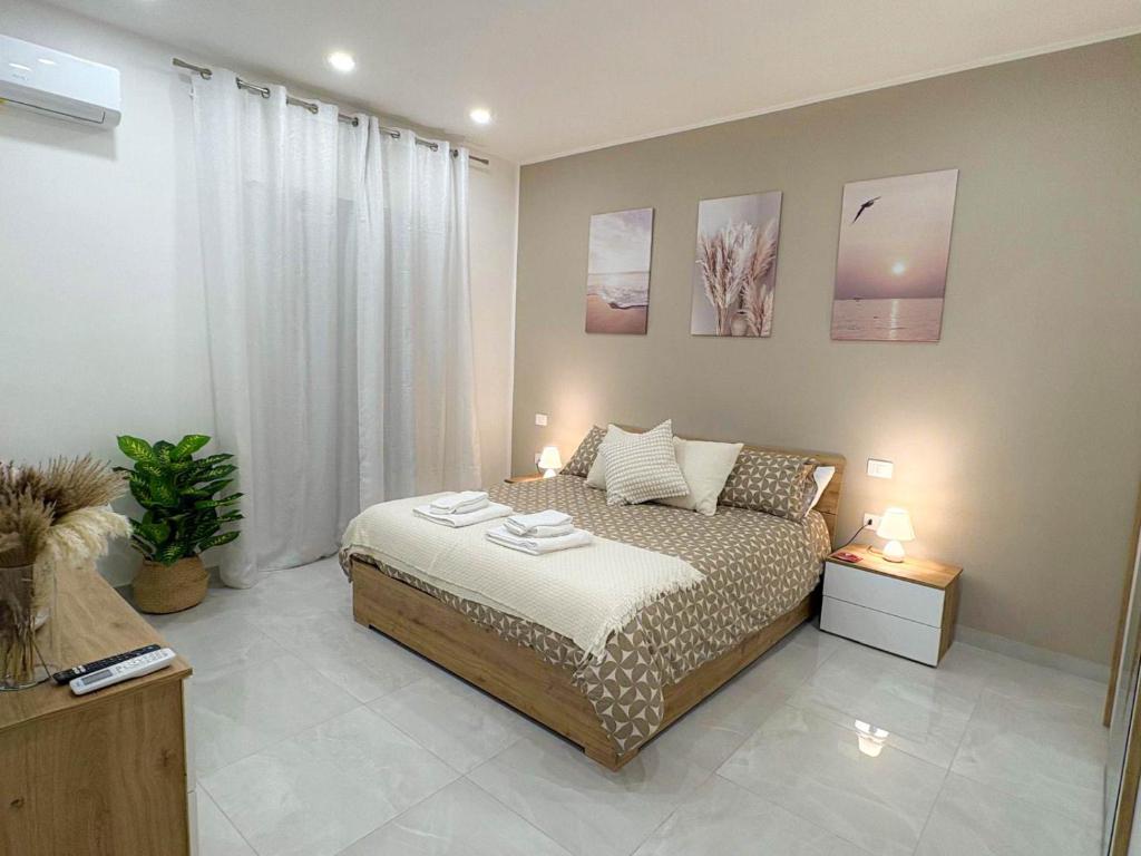 a bedroom with a bed and two lamps and a plant at Nicola's Apartments in Santa Maria La Carità