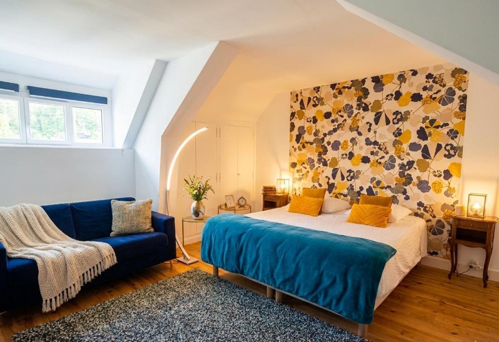 a bedroom with a bed and a blue couch at Le Huis Clos in Amboise