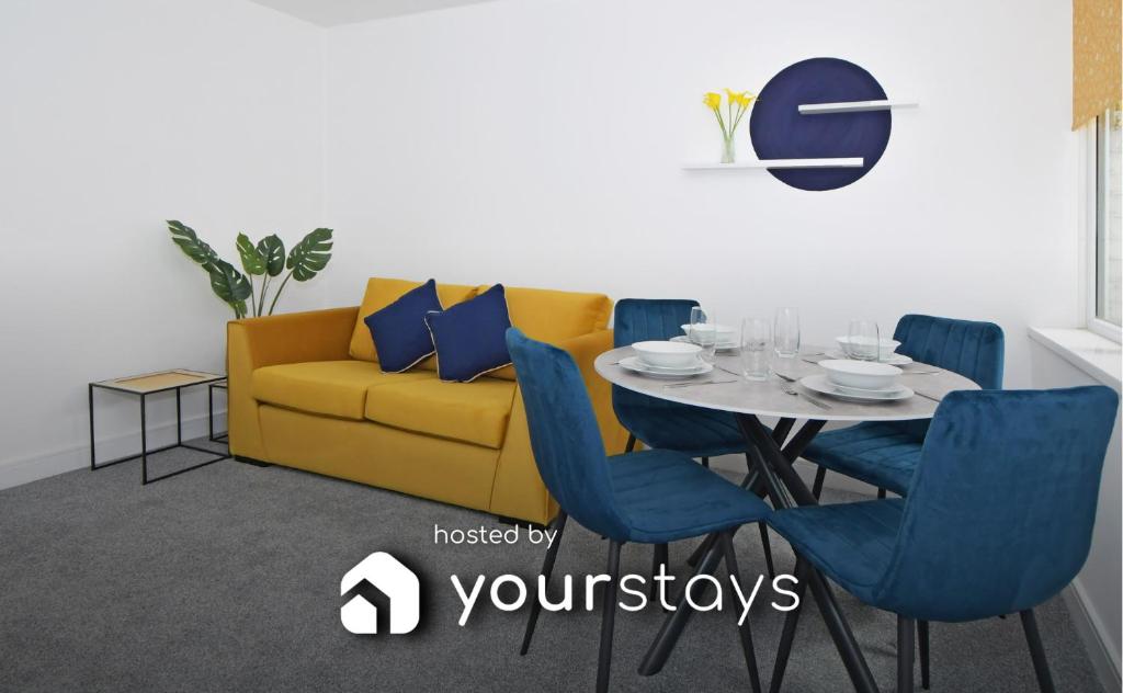 a dining room with a yellow couch and a table at Sapphire Apartments by YourStays - Comfy 1 Bedroom Apartments in Crewe in Crewe