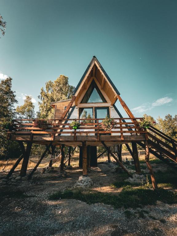 a house on a wooden structure with a roof at Acasa Straja - Treehouse in Lupeni