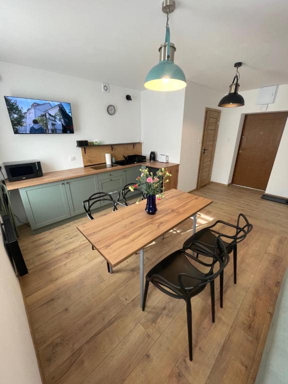 a kitchen with a wooden table with chairs and a table at Apartament JULIA in Głuszyca