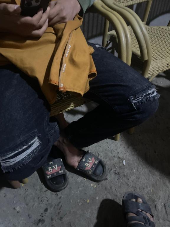 a person sitting on a chair wearing flip flops and shoes at Marassi in El Alamein