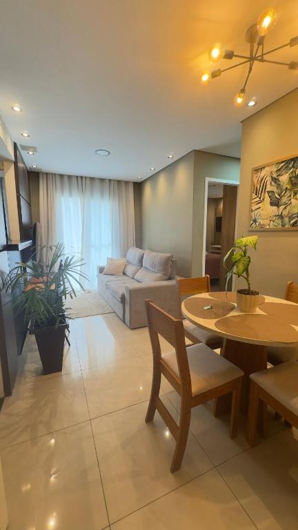 a living room with a couch and a table at Apartamento Exec Premium Queen Bed Centro-Taubate in Taubaté