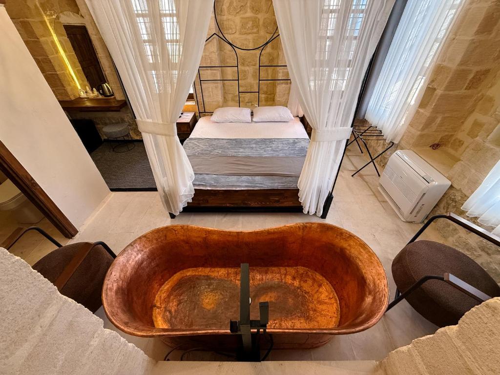 a bathroom with a wooden tub and a bed at Sümerler Konağı in Mardin