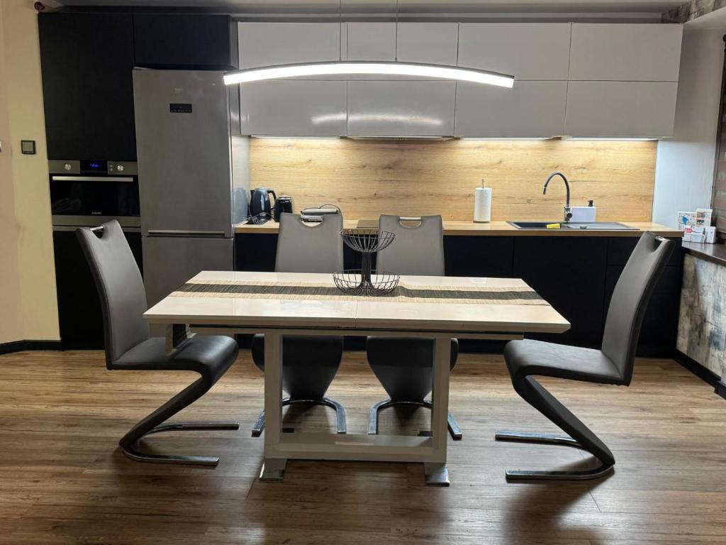 a kitchen with a table and chairs in a kitchen at Apartament Alan in Kłodzko
