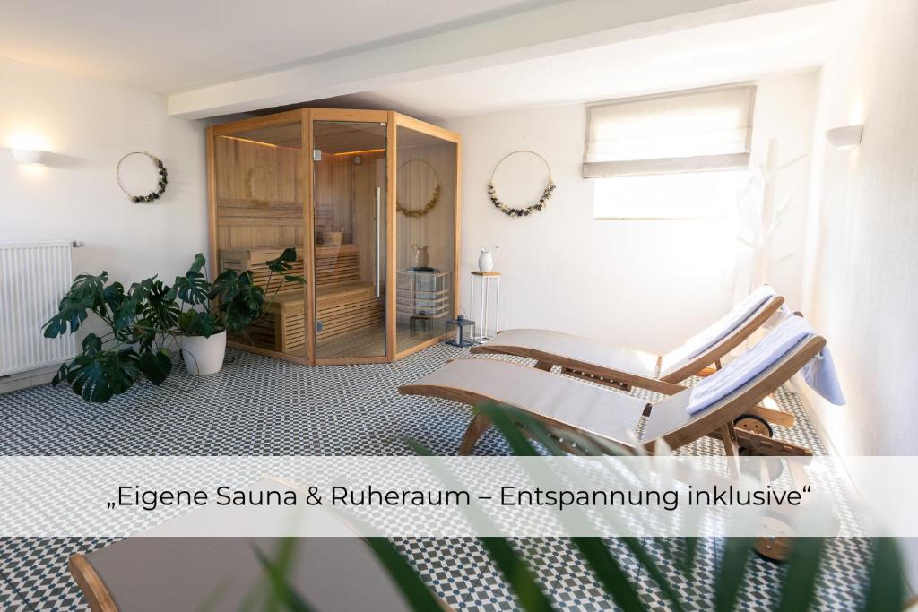a living room with two chairs and a cabinet at Landhaus Paco Ferienhaus für 12 Personen mit Alpakas, Sauna & Kamin in Blaufelden