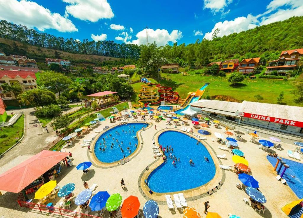 a large pool with umbrellas and people at a resort at China Park Eco Resort in Domingos Martins