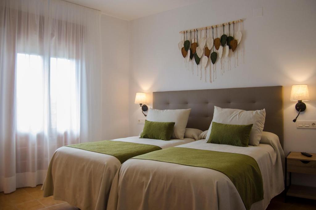 ein Schlafzimmer mit einem großen Bett mit grün-weißer Bettwäsche in der Unterkunft Las Perdices in Válor