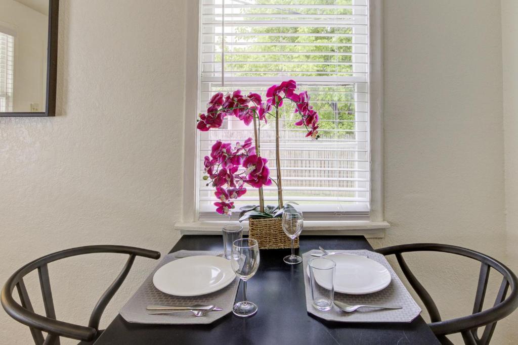 a table with two chairs and a vase with purple flowers at Jolly Jefferson Ave Walk to the Best of Midtown in Memphis