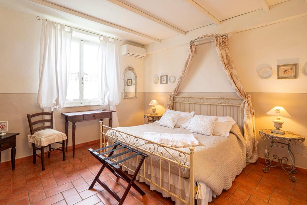 a bedroom with a bed and a desk and a window at Il Nido Di Anna in San Gimignano