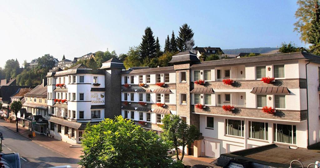 a group of buildings with red flowers on their windows at Hotel Garni Fürst von Waldeck in Willingen