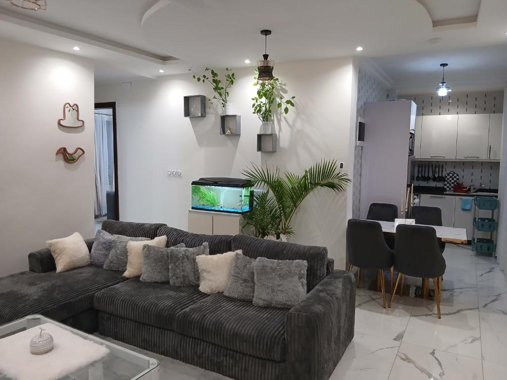 a living room with a couch and a fish tank on the wall at Résidence ABOMO'S in Kribi