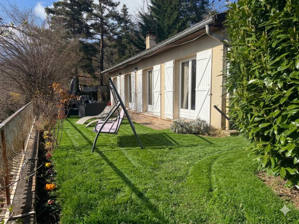 a yard with a swing in front of a house at Les Crins Du Bonheur Chambre et Table Hôtes Belle Vue in Fraisse