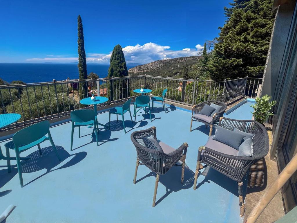 a patio with chairs and tables on a balcony at Villa Velta Calagrande in Porto Santo Stefano