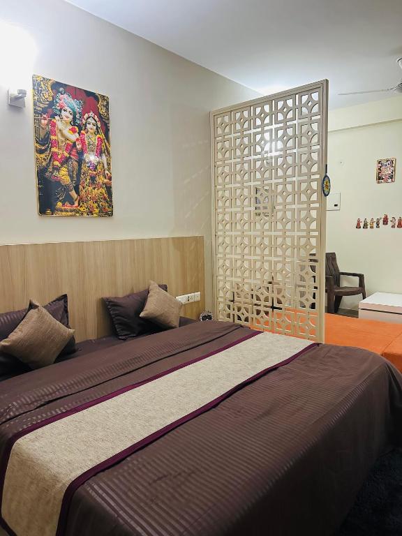 a bedroom with a bed and a painting on the wall at Kishori Ji Homes in Chhatikara