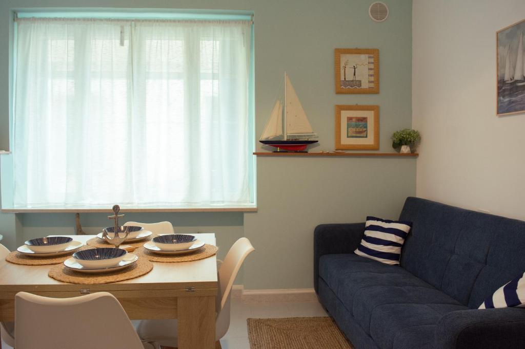 a living room with a table and a blue couch at Velaria Apartment in Termoli