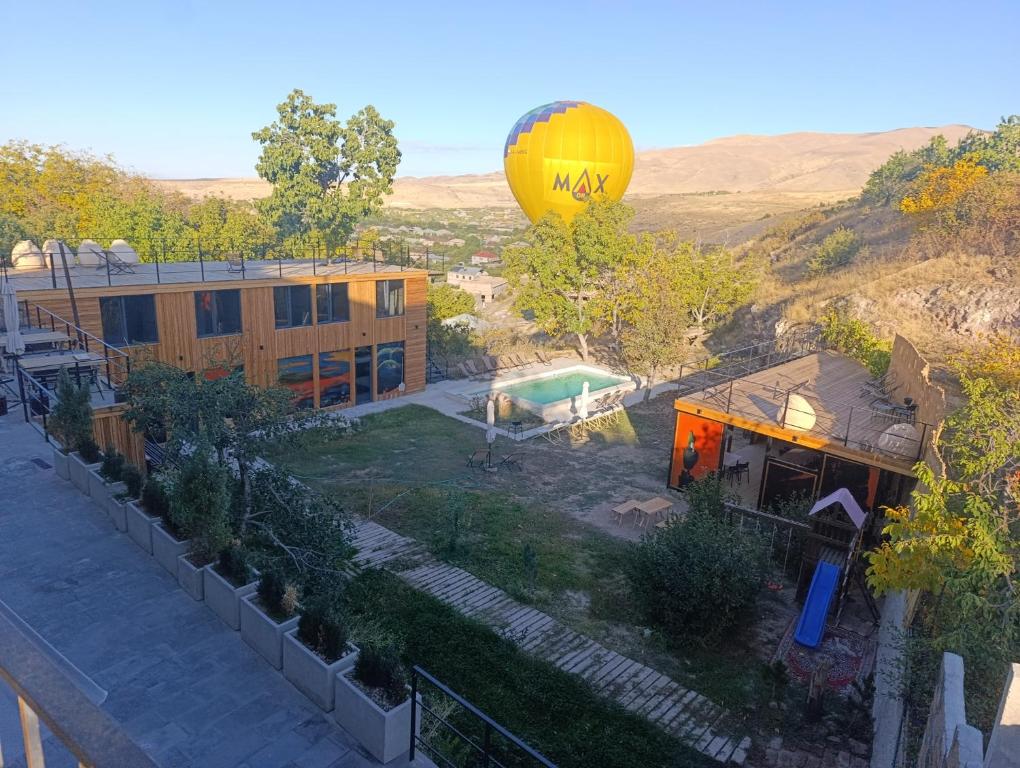 a hot air balloon flying over a house and a building at Azat - Toon in Garni