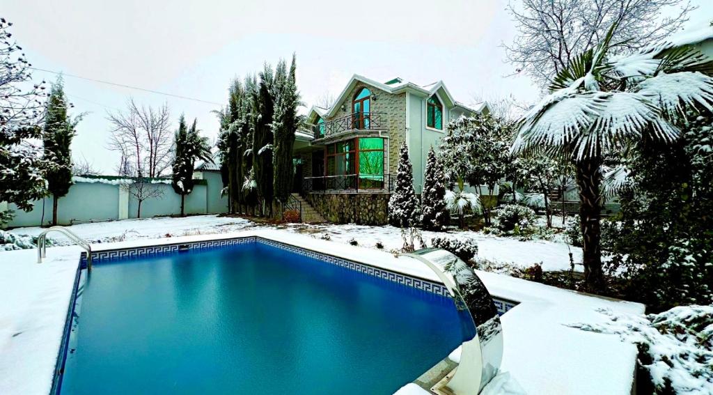 a swimming pool covered in snow in front of a house at Qebele hot pool in Gabala