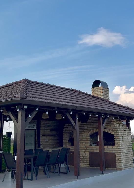a pavilion with chairs and a table on a patio at Vikendoria Pool House & Events in Bački Jarak