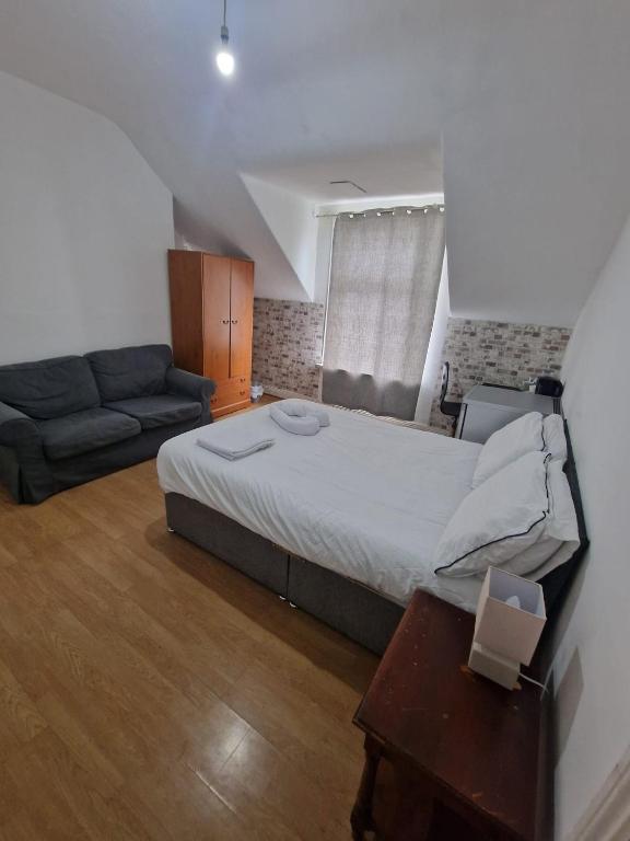a bedroom with a large bed and a couch at Princess Homestay in Sunderland