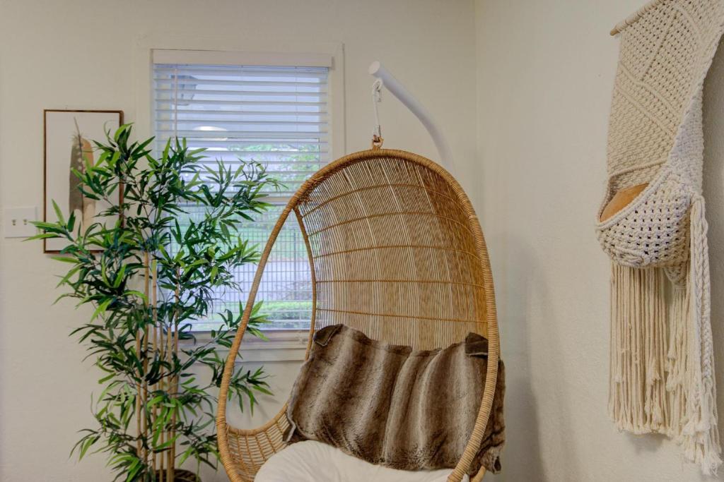 a rattan chair in a room with a window at Gated Cottage Community! Ideal Midtown Spot in Memphis