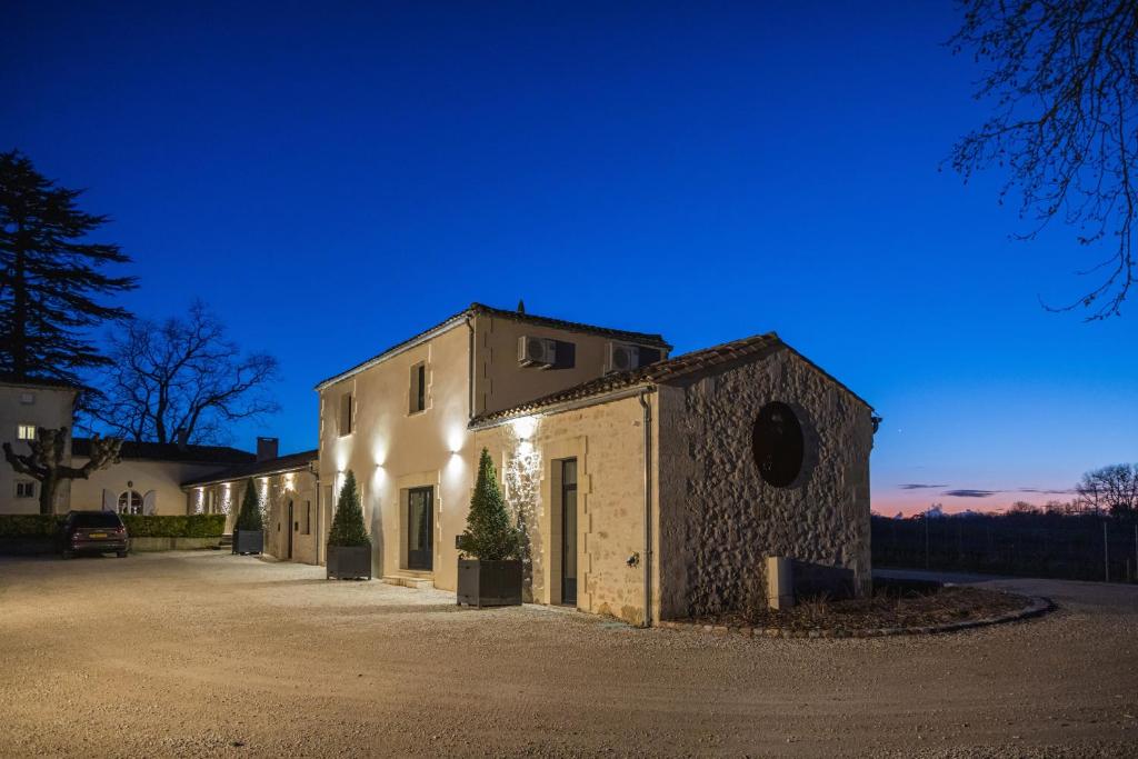 a building with lights on the side of it at L'Eperonnette, cozy house with swimming pool, surrounded by vineyard, near St Emilion in Vérac