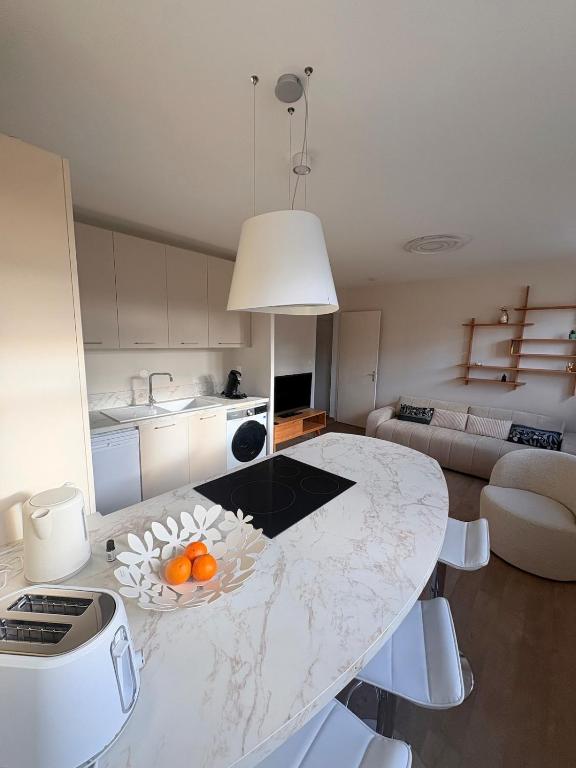 a kitchen with a table with oranges on it at Appartement Moderne & Spacieux - 5 min de la mer in Wimille