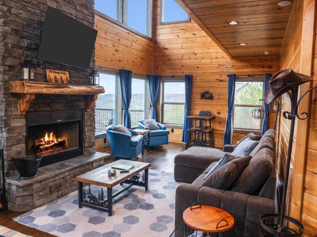 a living room with a couch and a fireplace at Luxury Cabin, Mtn Views, Theater, Game Room, 4BR in Gatlinburg